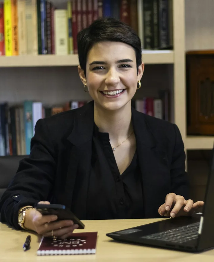 Portrait of Sofia, patient coordinator, smiling at her desk